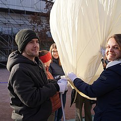 StudentInnen, die den Ballon mit Helium füllen.