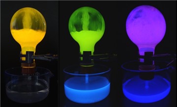 Bild zeigt 3 Kolben mit farbig fluoreszierenden Lösungen